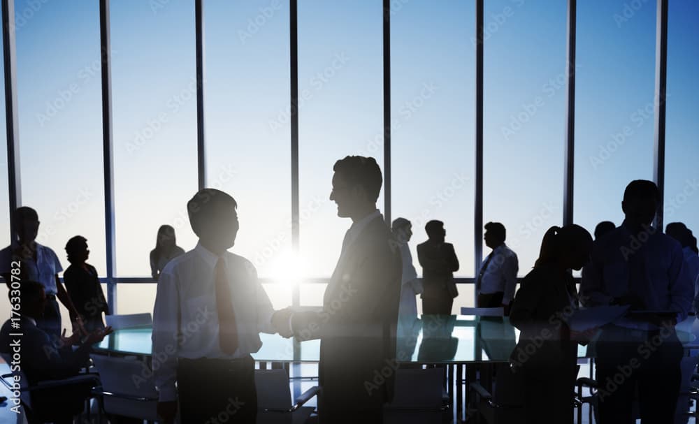 Professional business meeting with silhouetted figures in a modern conference room